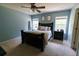 Inviting main bedroom with neutral carpet, a dark wood bed frame, a ceiling fan, and lots of light at 5094 Thornton Dr, Summerville, SC 29485