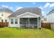 A well-maintained backyard featuring a screened porch and lush green lawn at 512 Alderly Dr, Moncks Corner, SC 29461