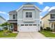 Charming two-story home with blue siding, well-manicured lawn, and a two car garage at 512 Alderly Dr, Moncks Corner, SC 29461