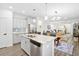 Open-concept kitchen flowing into the living room, featuring an island with seating and stainless appliances at 512 Alderly Dr, Moncks Corner, SC 29461
