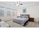 Bright main bedroom with tray ceilings, neutral decor, a ceiling fan, and three windows for natural light at 512 Alderly Dr, Moncks Corner, SC 29461