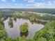 Beautiful aerial view of a tranquil pond surrounded by lush trees and a residential neighborhood at 520 Crossland Dr, Moncks Corner, SC 29461