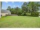 Expansive backyard featuring a lush lawn, mature trees, and a privacy fence at 520 Crossland Dr, Moncks Corner, SC 29461
