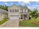 Charming two-story home featuring a cozy front porch, well-maintained lawn, and attached two-car garage at 520 Crossland Dr, Moncks Corner, SC 29461