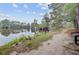 Scenic view of the pond with trees, calm waters, and a walking trail along the shore at 520 Crossland Dr, Moncks Corner, SC 29461