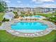 Aerial view of a luxurious community pool with ample seating, pergola, clubhouse, and playground area at 520 Crossland Dr, Moncks Corner, SC 29461