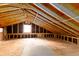 Spacious unfinished attic with exposed wooden beams and a window at 5322 Chantilly Ln, North Charleston, SC 29418