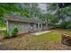 View of the backyard of a charming brick home with a well-kept lawn and mature trees offering ample shade at 5322 Chantilly Ln, North Charleston, SC 29418