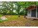 Backyard with mature trees, small shed, lawn, and landscaping at 5322 Chantilly Ln, North Charleston, SC 29418