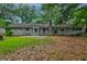 Expansive backyard showcasing a brick residence with a lush green lawn and mature trees providing a serene ambiance at 5322 Chantilly Ln, North Charleston, SC 29418