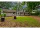 Spacious backyard featuring a brick home with a manicured lawn and towering trees, perfect for outdoor enjoyment at 5322 Chantilly Ln, North Charleston, SC 29418