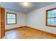 Sunny bedroom with wood floors, white walls, natural light from two windows, and closet at 5322 Chantilly Ln, North Charleston, SC 29418