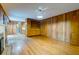 Open living area features wood floors, wood paneling, and access to the kitchen at 5322 Chantilly Ln, North Charleston, SC 29418