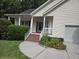 A charming front porch featuring brick steps, white railings, and views of the landscaped garden at 5347 Sundial Ct, North Charleston, SC 29418