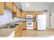 Well-lit kitchen features stainless sink, white appliances, and beautiful light wood cabinets at 5347 Sundial Ct, North Charleston, SC 29418