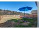 Backyard featuring a blue umbrella over a table and chairs, and a wood fence at 576 Polaris Way, Summerville, SC 29486