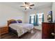 Bedroom with wood floors, ceiling fan, and a wooden bed frame with floral bedding at 576 Polaris Way, Summerville, SC 29486