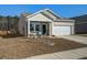 Charming home featuring beige siding, a two-car garage, and a welcoming front porch with colorful seating at 576 Polaris Way, Summerville, SC 29486