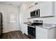 Kitchen with stainless steel appliances, granite countertops, white cabinets, and wood-look flooring at 576 Polaris Way, Summerville, SC 29486