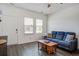 Cozy living room with a plush blue sofa, coffee table, and ample natural light from the nearby windows at 576 Polaris Way, Summerville, SC 29486
