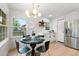 Bright dining area with modern lighting, stainless steel refrigerator, and views of the outdoors through large windows at 886 Friendly Cir, Charleston, SC 29414