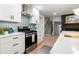 Bright kitchen features white cabinetry, stainless steel appliances, and a view of the staircase and fireplace at 886 Friendly Cir, Charleston, SC 29414