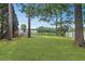 Lush green backyard with mature trees, offering a private outdoor retreat with lake views at 8967 N Red Maple Cir, Summerville, SC 29485