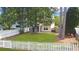 Well-maintained backyard with a white picket fence, mature trees, and lush green lawn at 8967 N Red Maple Cir, Summerville, SC 29485