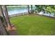 Spacious backyard featuring a lush lawn, wooden fence, and serene lake views at 8967 N Red Maple Cir, Summerville, SC 29485