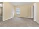 A spacious bedroom features a large window with wooded views and neutral colored walls and carpet at 8967 N Red Maple Cir, Summerville, SC 29485