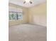 A spacious bedroom features a large window with wooded views and neutral colored walls and carpet at 8967 N Red Maple Cir, Summerville, SC 29485
