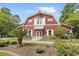 Charming red barn-style building with white trim, lush landscaping, and sidewalk at 8967 N Red Maple Cir, Summerville, SC 29485