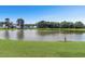 Scenic lake view with lush green grass and surrounding neighborhood homes at 8967 N Red Maple Cir, Summerville, SC 29485