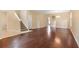 Open-concept living area featuring wood floors, a staircase, and an adjoining room with archway at 8967 N Red Maple Cir, Summerville, SC 29485