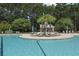 Resort-style pool area with lounge chairs, umbrellas, and lush tropical landscaping at 8967 N Red Maple Cir, Summerville, SC 29485