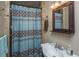 Bathroom with a sink, mirror, decorative curtain and neutral earth-tone tiled walls at 930 Stiles Dr, Charleston, SC 29412