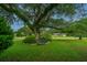 Lush front yard with a mature tree and garden with view of single story home in background at 930 Stiles Dr, Charleston, SC 29412