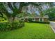 Beautifully landscaped front yard of a brick home, featuring mature trees and green grass at 930 Stiles Dr, Charleston, SC 29412