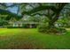 Charming brick home with a lush lawn and a large, mature tree providing shade at 930 Stiles Dr, Charleston, SC 29412
