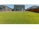 Large grassy backyard with a two-story home and privacy fences at 9711 Fanning Basket Ln, Ladson, SC 29456