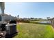 Backyard featuring a well-manicured lawn, a pond and a wooden fence at 9711 Fanning Basket Ln, Ladson, SC 29456