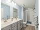 Bright bathroom with a double sink vanity, white shower-tub combo, and modern fixtures at 9711 Fanning Basket Ln, Ladson, SC 29456