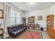 Bright office space with large window, bookshelves, and sleek futon couch at 9711 Fanning Basket Ln, Ladson, SC 29456
