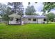 Charming backyard featuring a well-maintained lawn and a covered porch, perfect for outdoor relaxation at 103 Four Iron Dr, Summerville, SC 29483