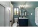 This compact bathroom features a blue vanity, toilet, and white towel with a window at 103 Four Iron Dr, Summerville, SC 29483