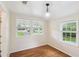 Well-lit bedroom with three windows, hardwood floors and chandelier at 106 N Pine St, Summerville, SC 29483