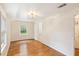 Bright bedroom featuring hardwood floors, a window, and an ornate ceiling light fixture at 106 N Pine St, Summerville, SC 29483