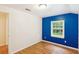 Bright bedroom with a blue accent wall, hardwood floors, and natural light at 106 N Pine St, Summerville, SC 29483