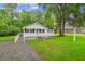 Classic single-story home with a covered porch, features a grassy front yard and mature trees at 106 N Pine St, Summerville, SC 29483