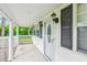 Covered front porch features black sconce lighting, white railing, and decorative white door at 106 N Pine St, Summerville, SC 29483